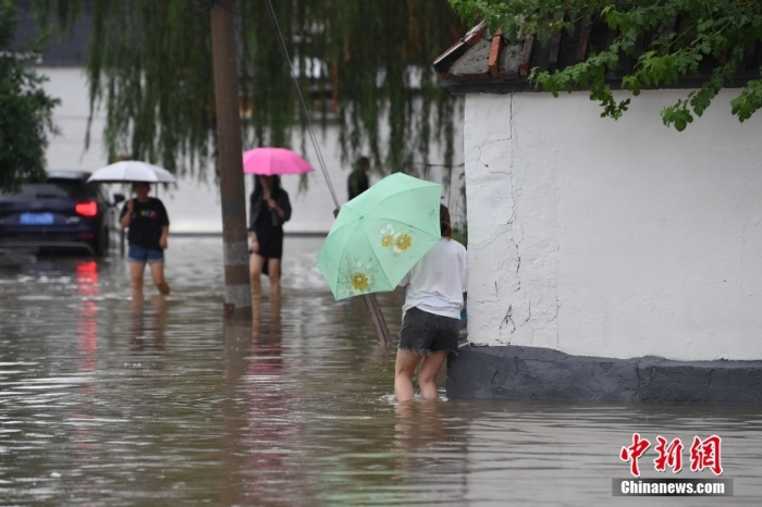 7月31日，市民行走在雨中的北京房山區(qū)瓦窯頭村。北京市氣象臺(tái)當(dāng)日10時(shí)發(fā)布分區(qū)域暴雨紅色預(yù)警信號(hào)。北京市水文總站發(fā)布洪水紅色預(yù)警，預(yù)計(jì)當(dāng)日12時(shí)至14時(shí)，房山區(qū)大石河流域?qū)⒊霈F(xiàn)紅色預(yù)警標(biāo)準(zhǔn)洪水。<a target='_blank' href='/'><p  align=