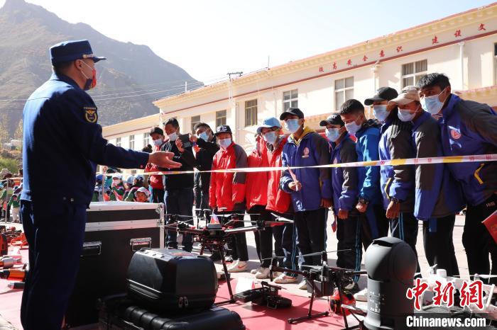 圖為消防指戰(zhàn)員為學(xué)生講解、演示先進(jìn)救援裝備?！≮w琳 攝