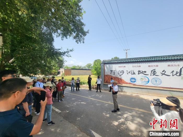 圖為中國地質(zhì)大學(北京)教授張緒教介紹村落情況?！『衍?攝