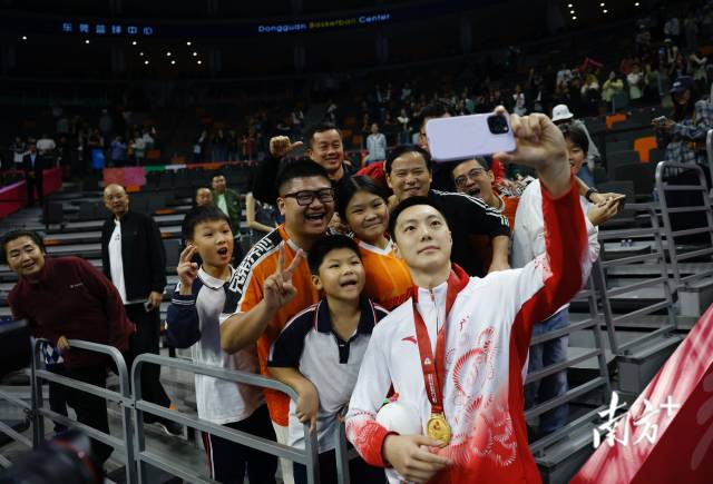 11月12日，十五運會男籃成年組決賽，廣東隊獲得冠軍后，胡明軒與球迷們合影留念。張由瓊 攝