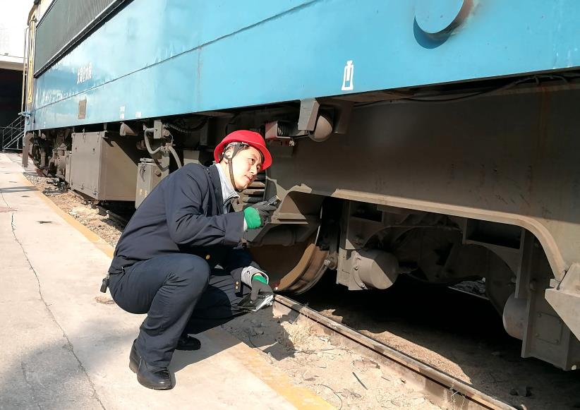 韓文盛全神貫注檢查機(jī)車走行部。