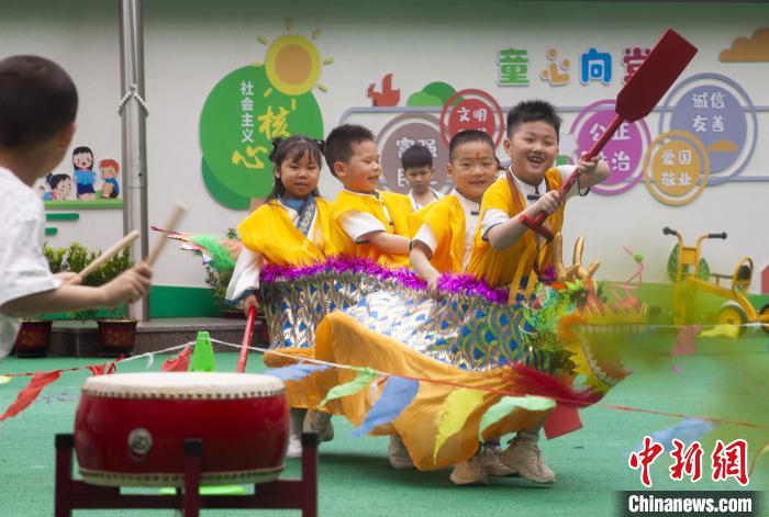 圖為龍舟賽游戲上，小伙伴們打鼓加油?！《^生 攝